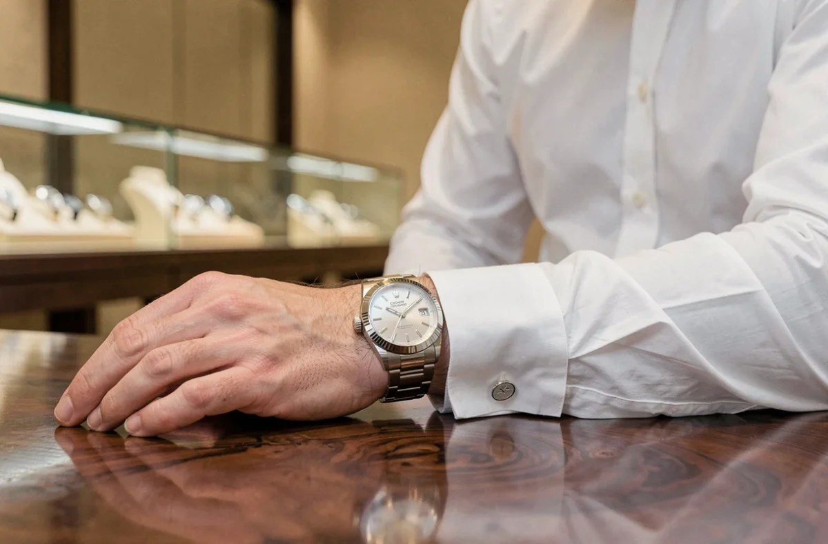 Homme portant une Rolex Oyster Perpetual en acier dans une boutique horlogère suisse